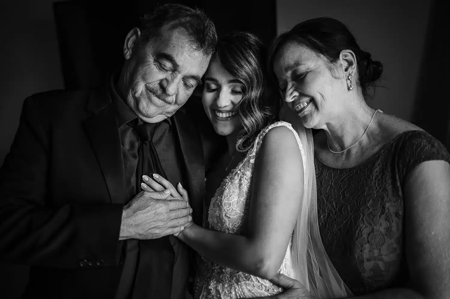 Papa y mamá de la novia abrazan a su hija momentos previos antes de salir de su casa para dirigirse a la ceremonia | Fotógrafo de Bodas Costa Rica
