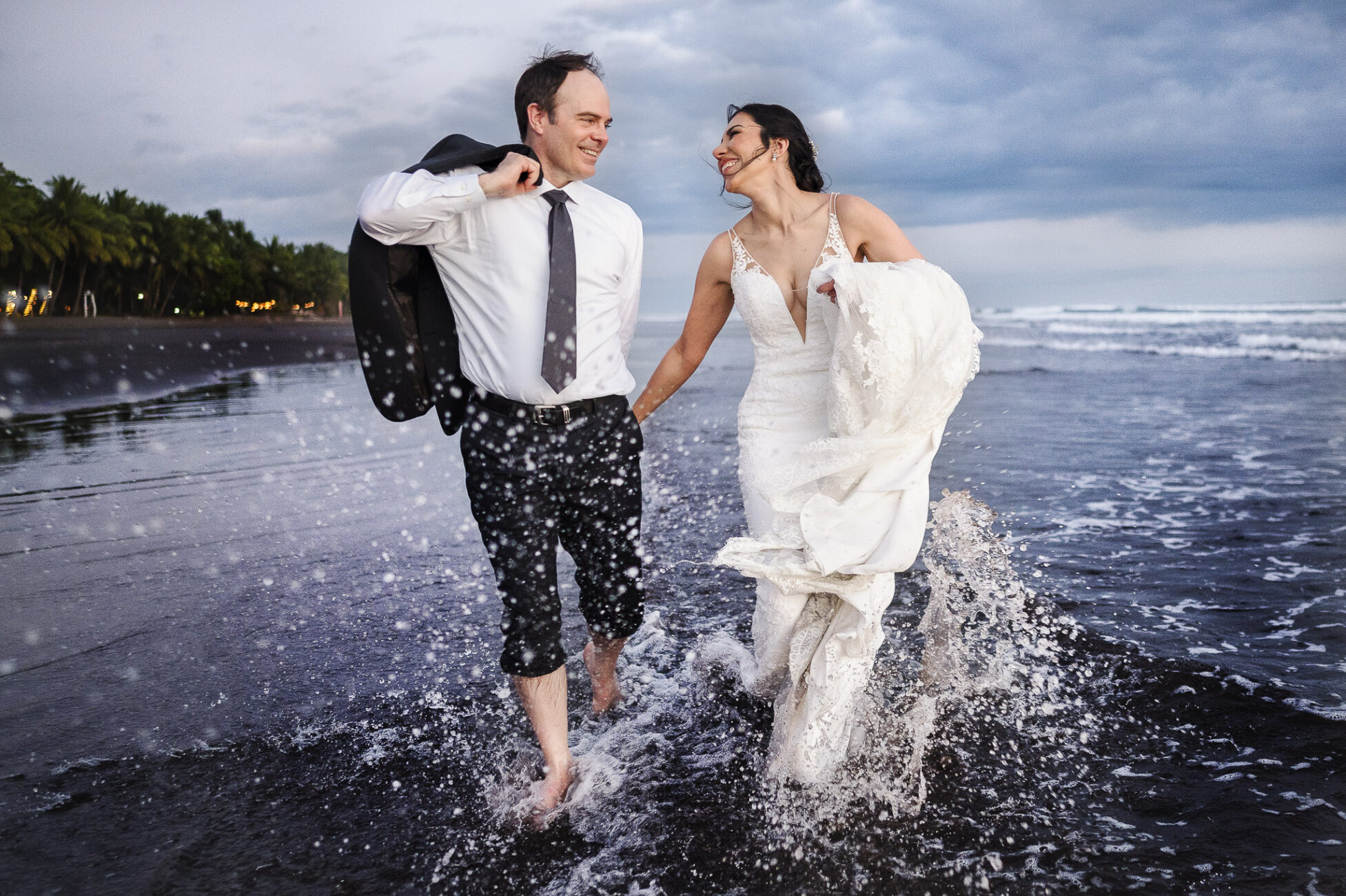 Bride and Groom running through the beach having fun at their Costa Rica Beach Elopement during their portrait session after the ceremony.