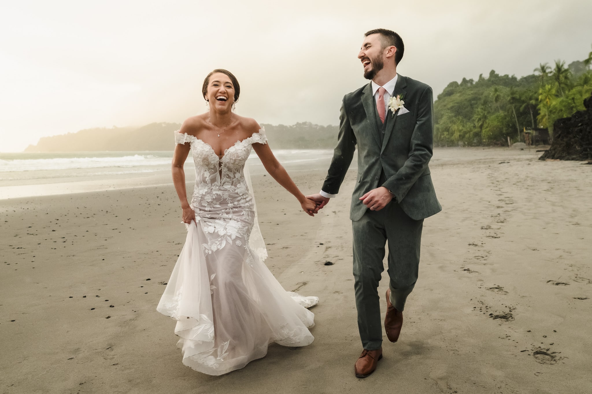 Bride and groom running and having fun through Manuel Antonio Beach during their Costa Rica Destination Wedding portrait session.